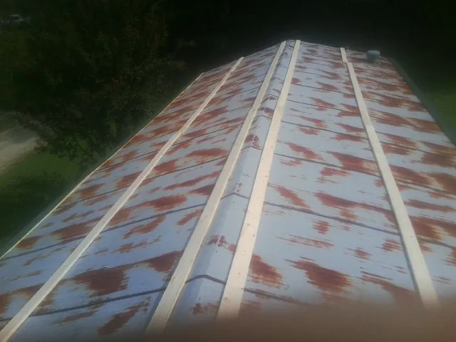 Rusted metal roof panels with new wood purlins before replacement — Storm Damage Roof Repair in Port Orange by Roofing Brothers