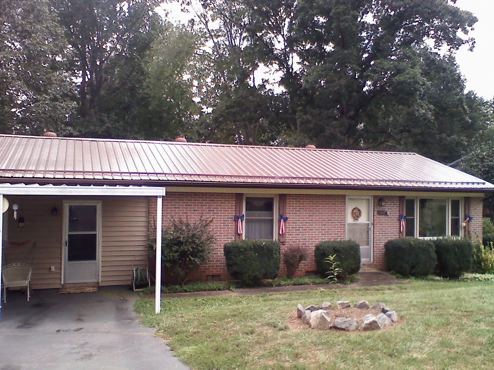 Bronze metal roof and carport on a brick ranch home — Roof Repair work by our crew in Port Orange